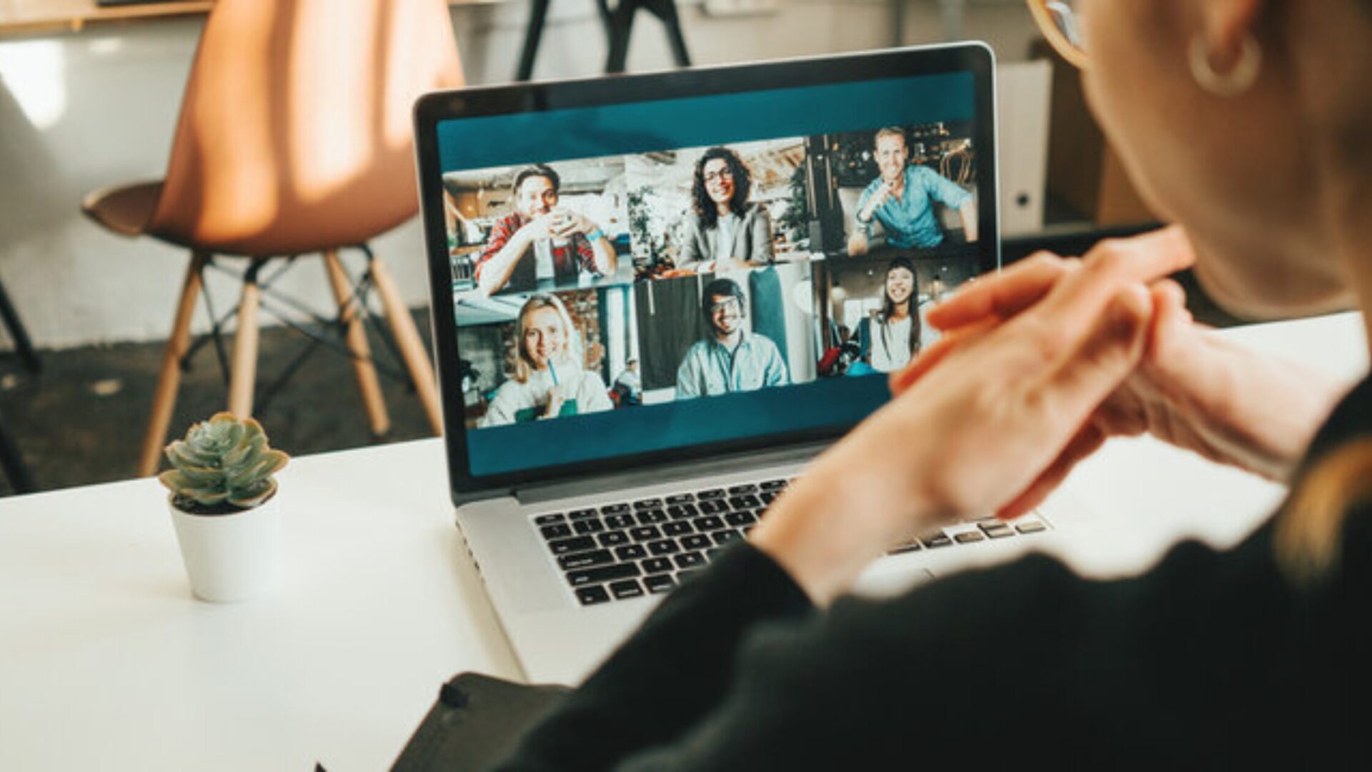 A woman video conferences with colleagues on laptop representing the best strategies for Remote Work Management